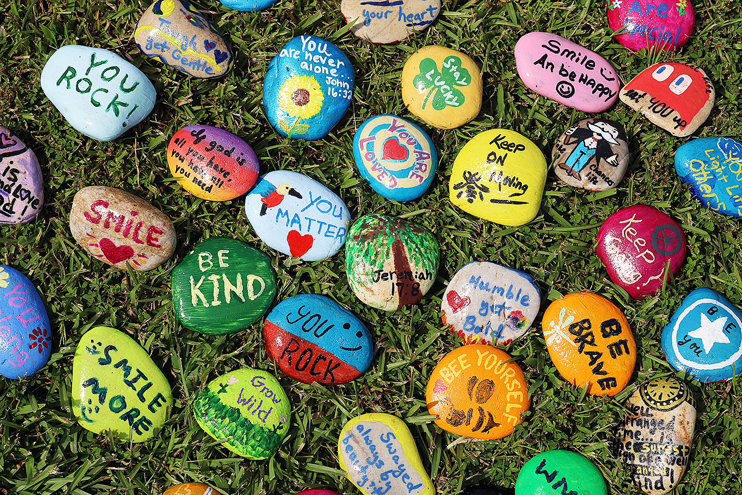 Several rocks painted different colors with words of encouragement