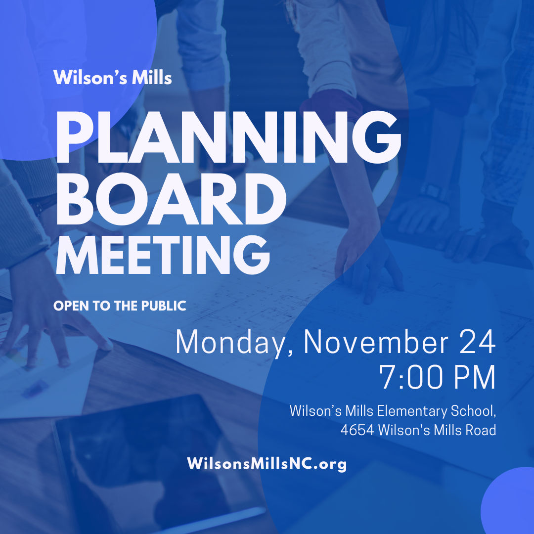 People standing around table pointing at blueprints